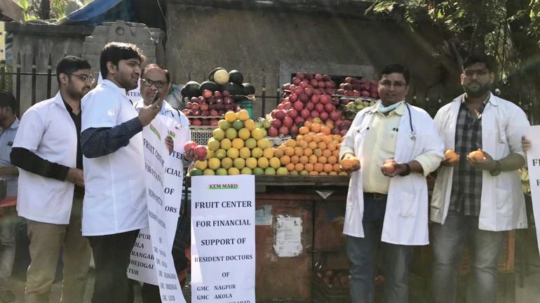 स्टेथोस्कोपच्या जागी हातात फळ आणि वजनकाटा स्टेथोस्कोपच्या जागी हातात फळ आणि वजनकाटा