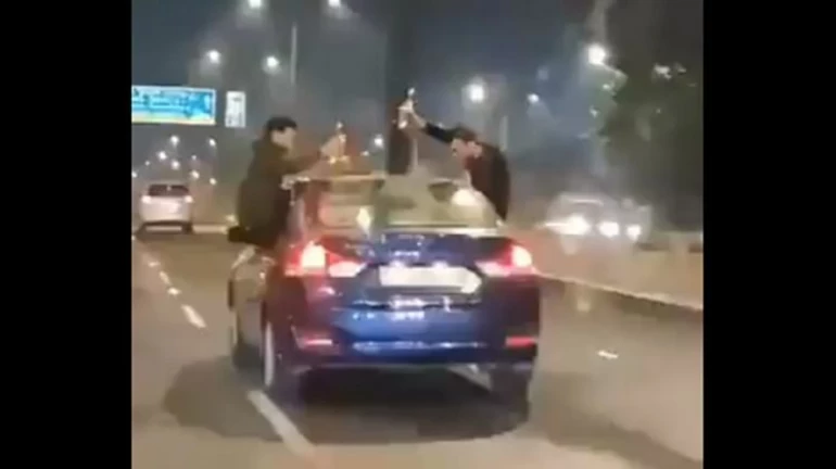 धावत्या कारमध्ये खिडकीत बसून मद्यप्राशन,  पोलिसांची कारवाई धावत्या कारमध्ये खिडकीत बसून मद्यप्राशन,  पोलिसांची कारवाई