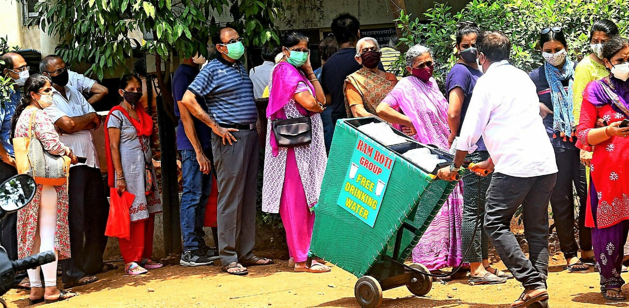 Mumbai: Ram Roti organisation provides free drinking water to people standing in queues for COVID-19 vaccine