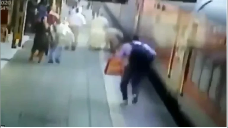 Woman tries to board a moving train, slips; RPF constable saves her Woman tries to board a moving train, slips; RPF constable saves her